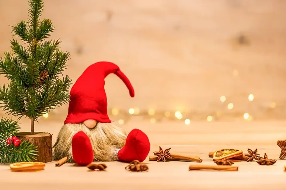 Weihnachtswichtel an Miniatur-Tannenbaum auf Holztisch. Daneben Sternanis, Zimt und getrocknete Orangenscheiben